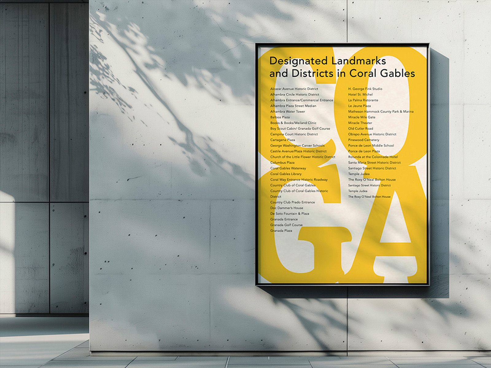 Framed yellow poster on a gray wall listing designated landmarks and districts in Coral Gables, with dense text in black.